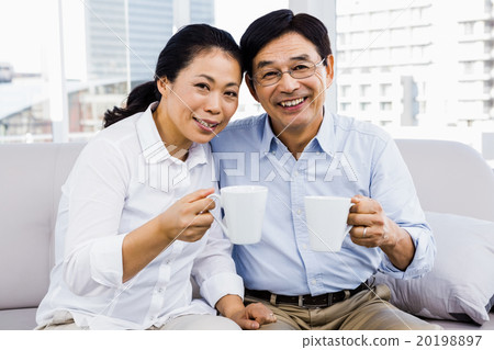Potrait of couple enjoying coffee on the couch Potrait of couple enjoying coffee on the couch 20198897