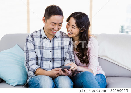 Young happy couple using smart phone Young happy couple using smart phone 20199025