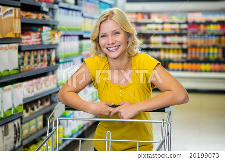 Portrait of smiling blonde woman in aisle Portrait of smiling blonde woman in aisle 20199073