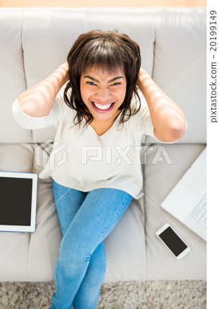 Woman with her hands behind her head 20199149