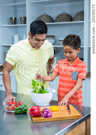 Smiling father preparing salad with his son Smiling father preparing salad with his son 20199273