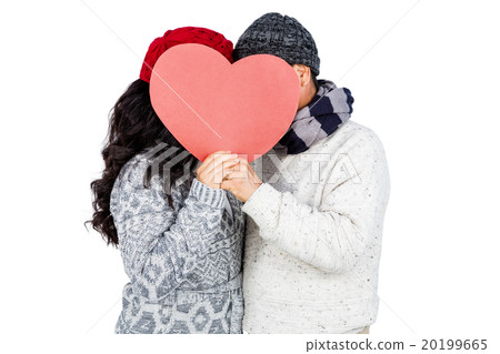 Couple hiding behind heart shape cardboard 20199665