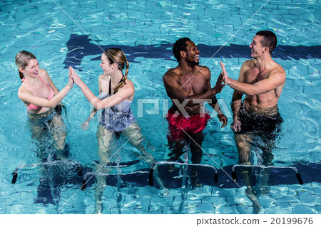 Fit smiling group pedaling on swimming bike 20199676