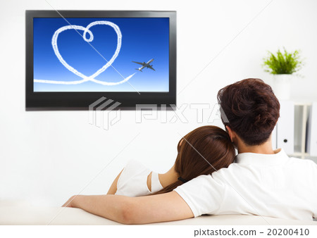 young couple watching the  tv show in living room 20200410