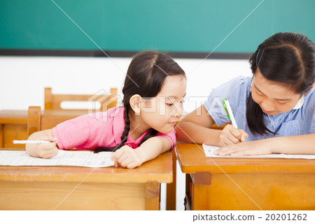 little girl student trying to cheat at test in class little girl student trying to cheat at test in class 20201262