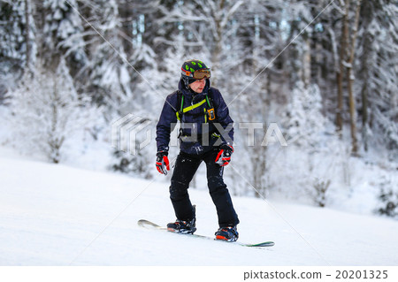 Snowboarder in black suit slides down  20201325