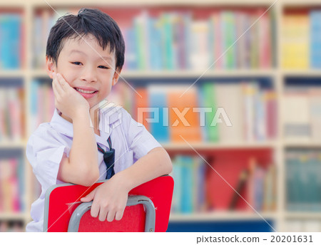 boy student in uniform reading book in library 20201631