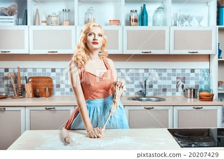 Girl kneads dough in the kitchen and dreams. 20207429