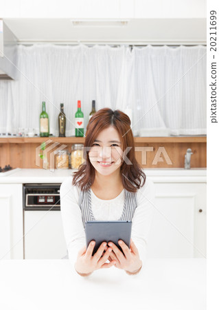 A housewife using a tablet in the kitchen 20211699