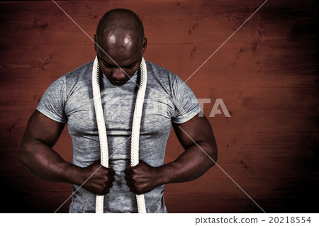 Composite image of fit man with battle rope Composite image of fit man with battle rope 20218554