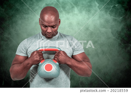 Composite image of fit man exercising with kettlebell Composite image of fit man exercising with kettlebell 20218559