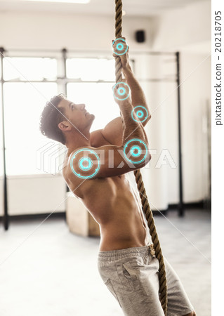 Composite image of side view of muscular man doing rope climbing 20218705