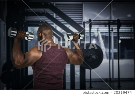 Composite image of fit man exercising with dumbbell  20219474