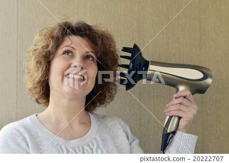 Woman doing curls with  hairdryer and diffuser 20222707