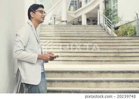 casual indian male using tablet outdoor casual indian male using tablet outdoor 20239748