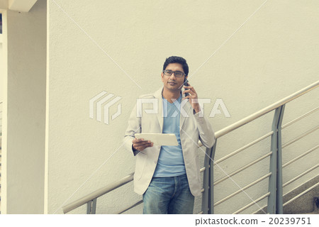 casual indian male using tablet outdoor casual indian male using tablet outdoor 20239751