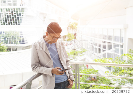 casual indian male using phone outdoor casual indian male using phone outdoor 20239752