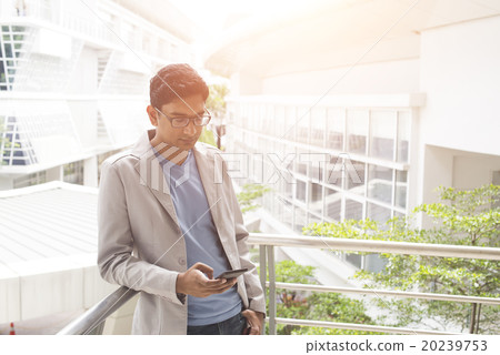casual indian male using phone outdoor casual indian male using phone outdoor 20239753