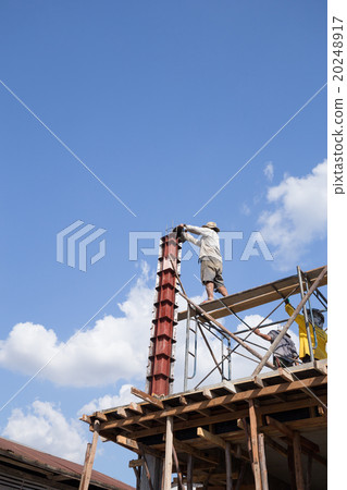 worker pouring cement to concrete pillar  20248917