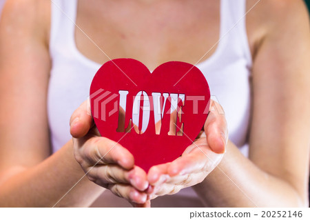 Beautiful girl holding a heart in hands Beautiful girl holding a heart in hands 20252146