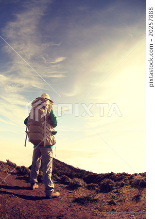 young woman backpacker hiking on mountain peak 20257888