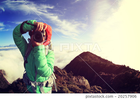 young woman photographer taking photo on beautiful mountain peak 20257906