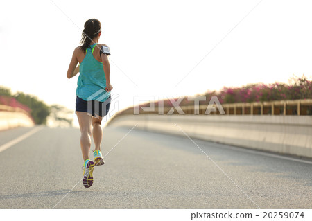 young woman runner running on city bridge road young woman runner running on city bridge road 20259074