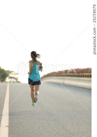 young woman runner running on city bridge road young woman runner running on city bridge road 20259079