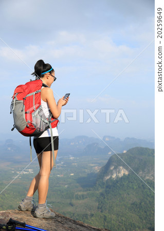 young woman hiker use cellphone on mountain peak young woman hiker use cellphone on mountain peak 20259649