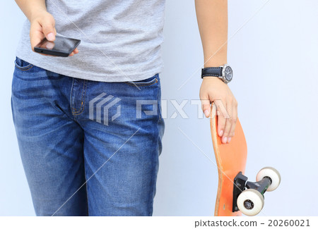 skateboarder use cellphone lean on wall 20260021