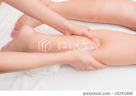 Therapist doing reflexology massage on woman leg  20291006