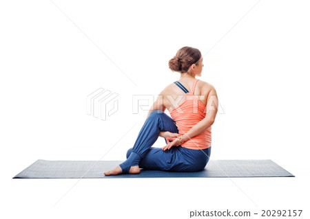 Woman practices yoga asana  Ardha matsyendrasana 20292157