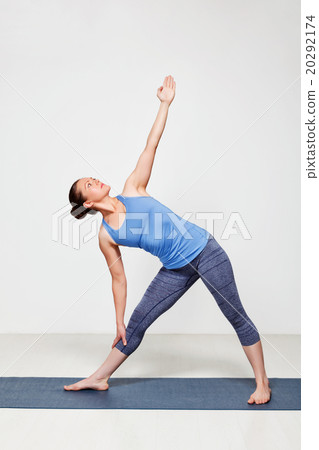 Woman doing yoga asana utthita trikonasana 20292174