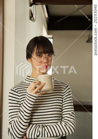 A woman in her twenties relaxing at the window 20293040