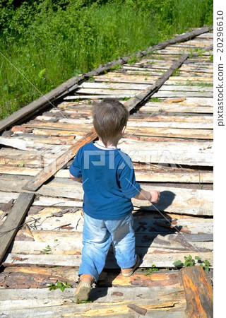 Small boy walks on wooden flooring 20296610