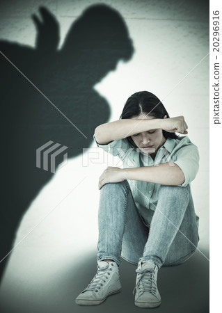 Composite image of sad woman sitting on the floor and hiding her Composite image of sad woman sitting on the floor and hiding her 20296916