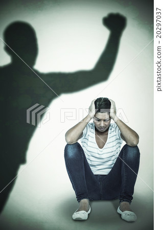 Composite image of depressed woman crouching on white background 20297037