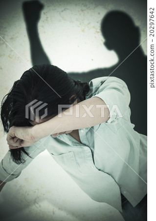 Composite image of sad woman sitting on the floor and hiding her 20297642