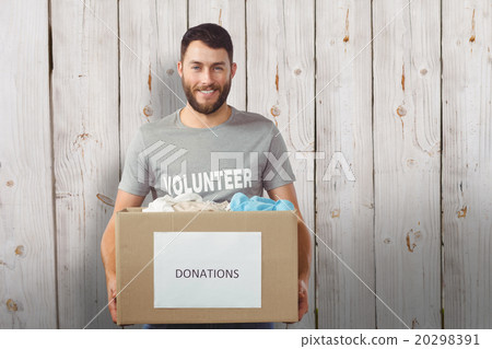 Composite image of portrait of man holding clothes donation box Composite image of portrait of man holding clothes donation box 20298391