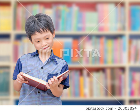 Asian boy student reading book in school library Asian boy student reading book in school library 20303854