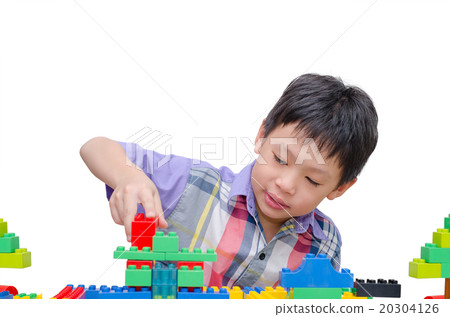 Asian boy playing construction block over white Asian boy playing construction block over white 20304126