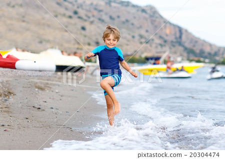 little blond kid boy running ocean beach 20304474