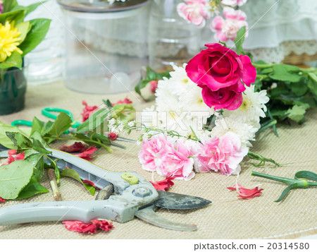 Scissor on table of flowers arrangement. Scissor on table of flowers arrangement. 20314580