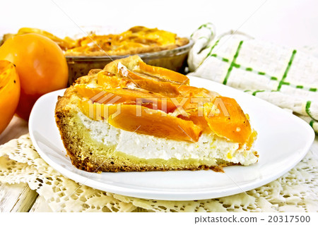 Pie with curd and persimmons in plate on napkin 20317500