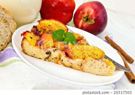 Pudding from bread and peaches with milk on board 20317503