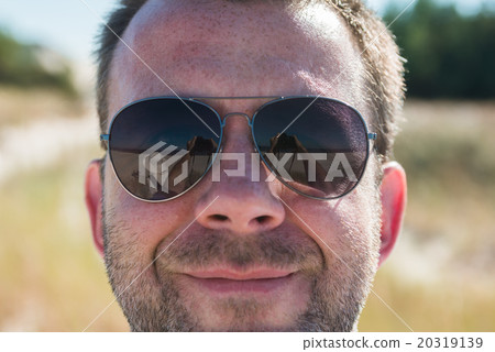 Man taking a picture of himself and woman reflecing in singlasse 20319139