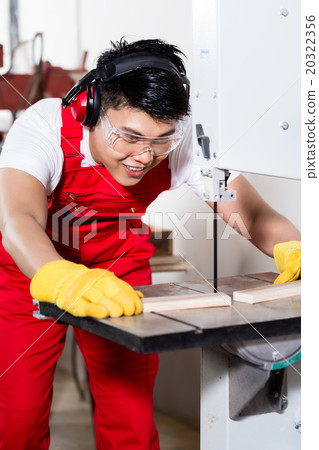 Chinese worker on saw in industrial factory 20322356