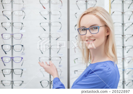 Beautiful blond girl wants to buy eyeglasses 20322897