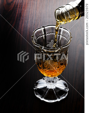 Pouring whiskey into cup before meal 20323979