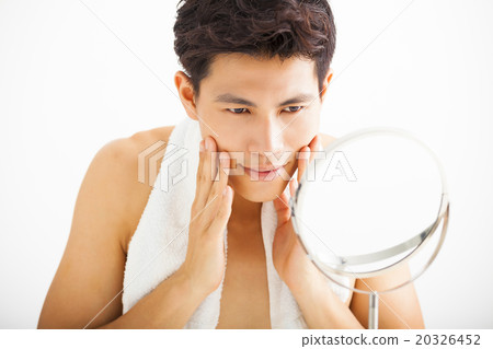 Young  man touching his smooth face after shaving 20326452